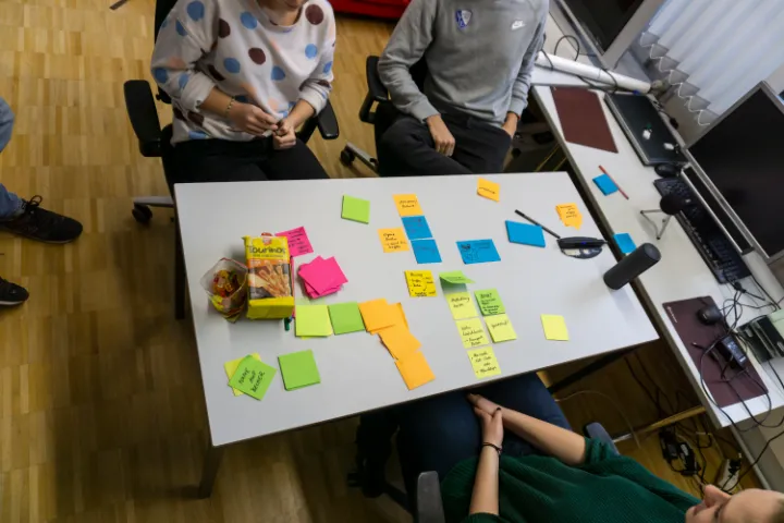 Overhead view of a team brainstorming with sticky notes on a table.